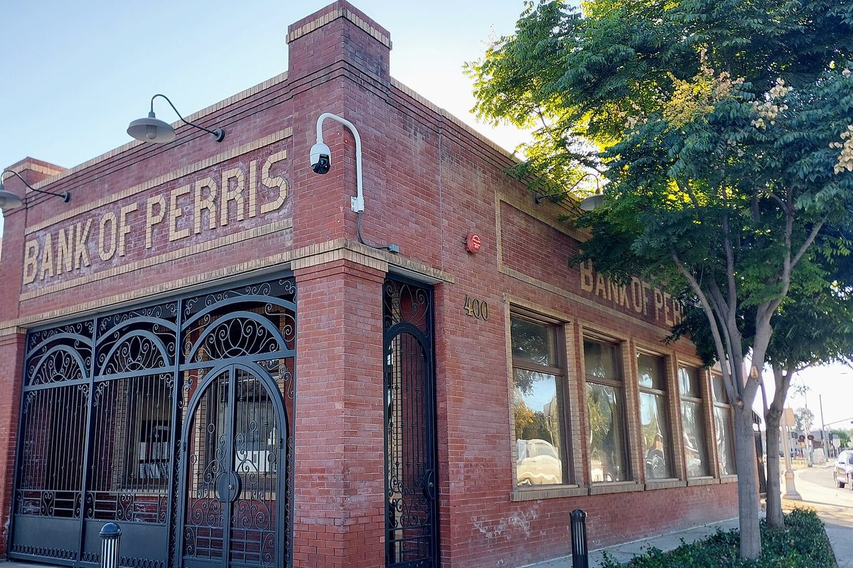 Historic Bank of Perris brick building with an iron gate in downtown Perris, California